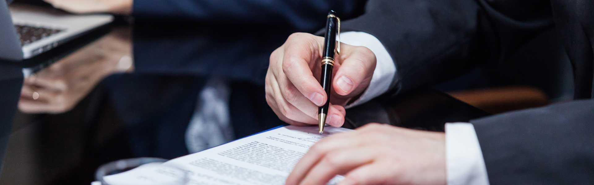 A man signing business papers.