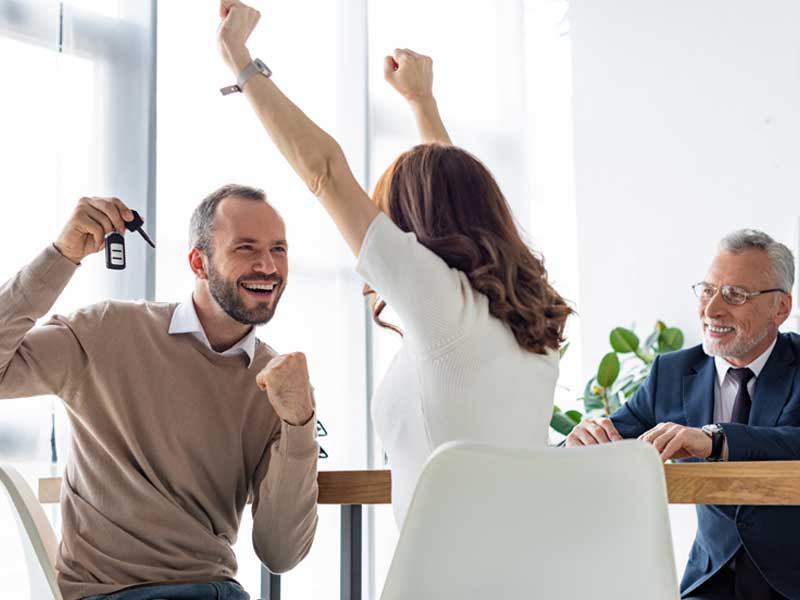 Couple celebrating car loan.