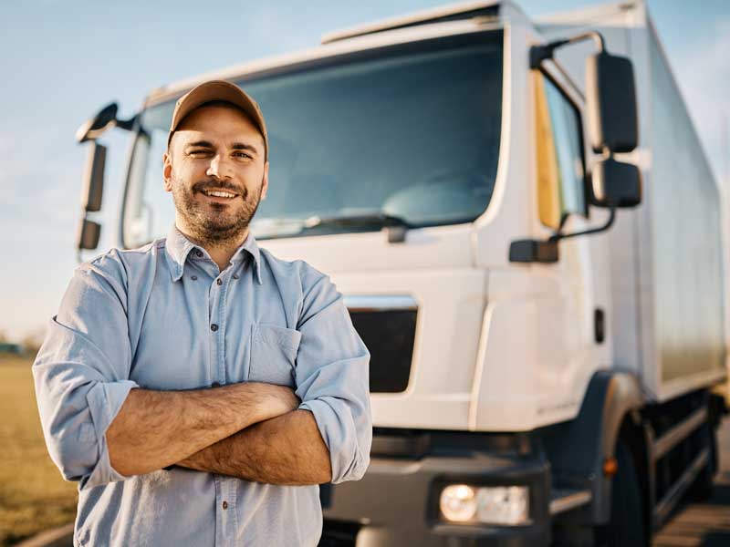 Happy man standing infront of his truck.